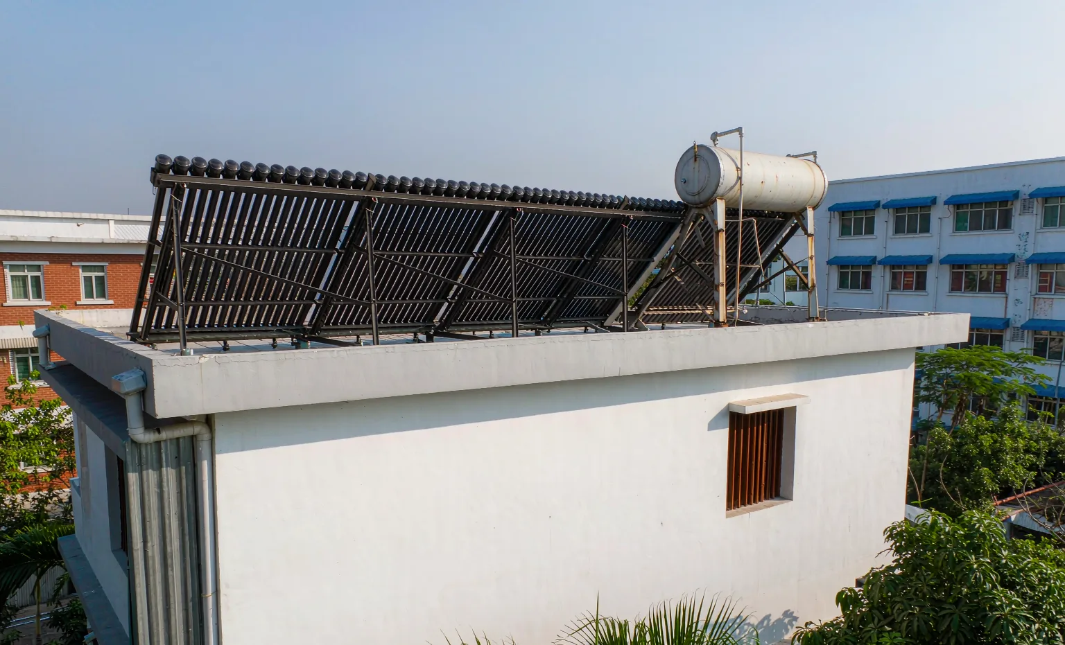 Evacuated tube solar water heater with tank installed on the flat roof of a residential building in Nigeria