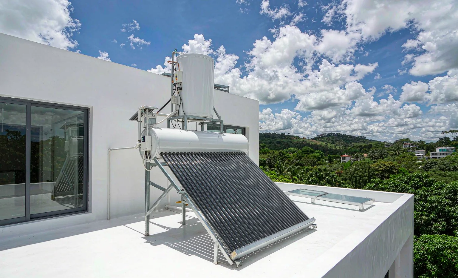 Solar water heater with evacuated tube collectors and tank on the roof of a modern house in Kampala, Uganda