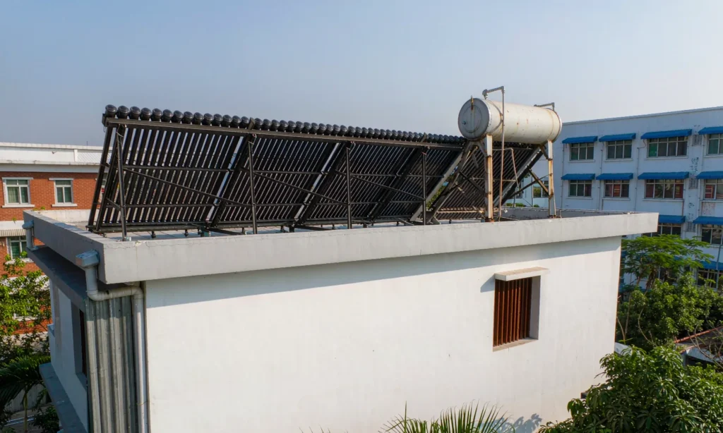 Evacuated tube solar water heater array with storage tank mounted on a flat roof
